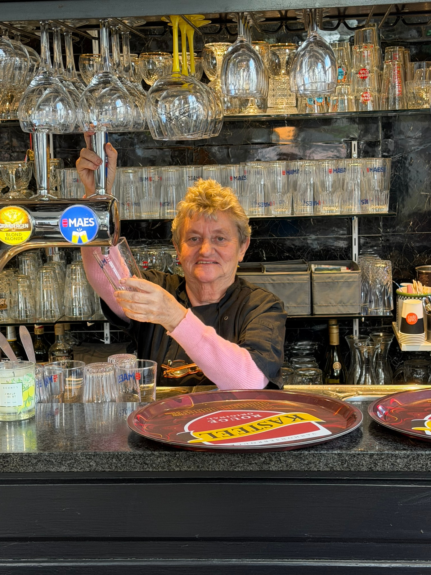 Marianne, la patronne du Saint d'Hic III, servant une bière au bar